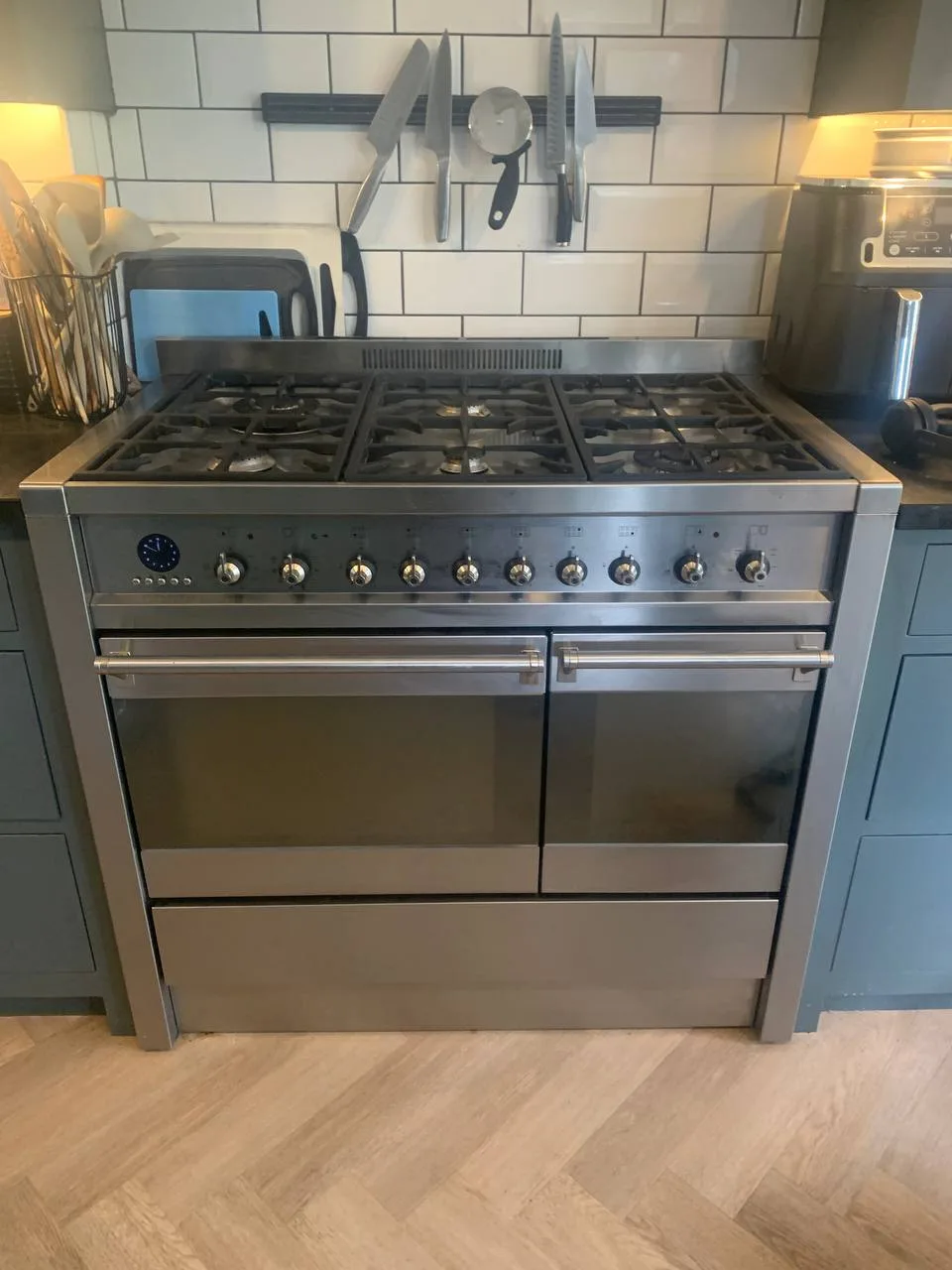 Stainless steel range cooker with a gas hob and two ovens, clean after cleaning.